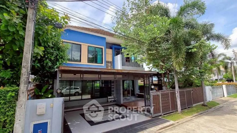 Charming two-story blue house with lush greenery and spacious driveway in a serene neighborhood.