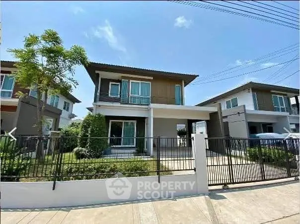 Modern two-story house with a spacious front yard and sleek design in a suburban neighborhood.