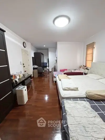 Spacious bedroom with wooden flooring and modern furnishings