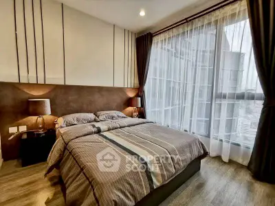 Modern bedroom with large window and stylish decor in high-rise apartment.