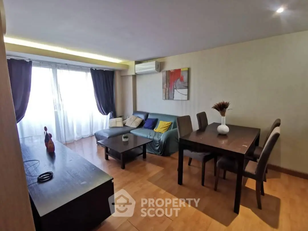 Spacious living room with modern decor and natural light, featuring a cozy sofa and dining area.