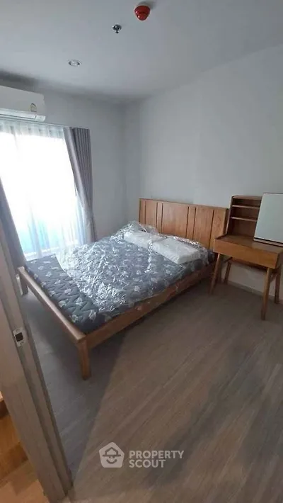 Cozy bedroom with wooden furniture and natural light from large window