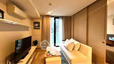 Modern living room with cozy sofa, TV, and large window in stylish apartment.