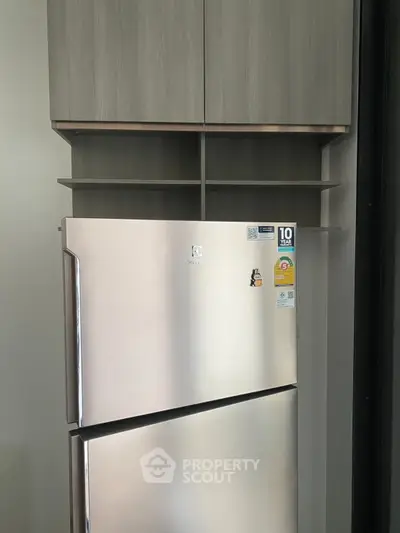 Modern kitchen with sleek stainless steel refrigerator and custom cabinetry.