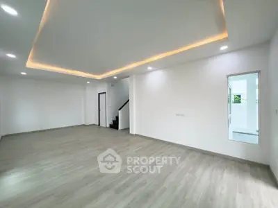 Spacious modern living room with sleek lighting and wooden flooring