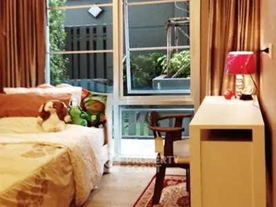 Cozy bedroom with large window and stylish decor, perfect for relaxation.