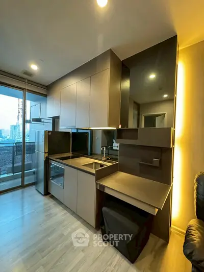 Modern kitchen with sleek cabinetry and open layout, featuring city view balcony access.