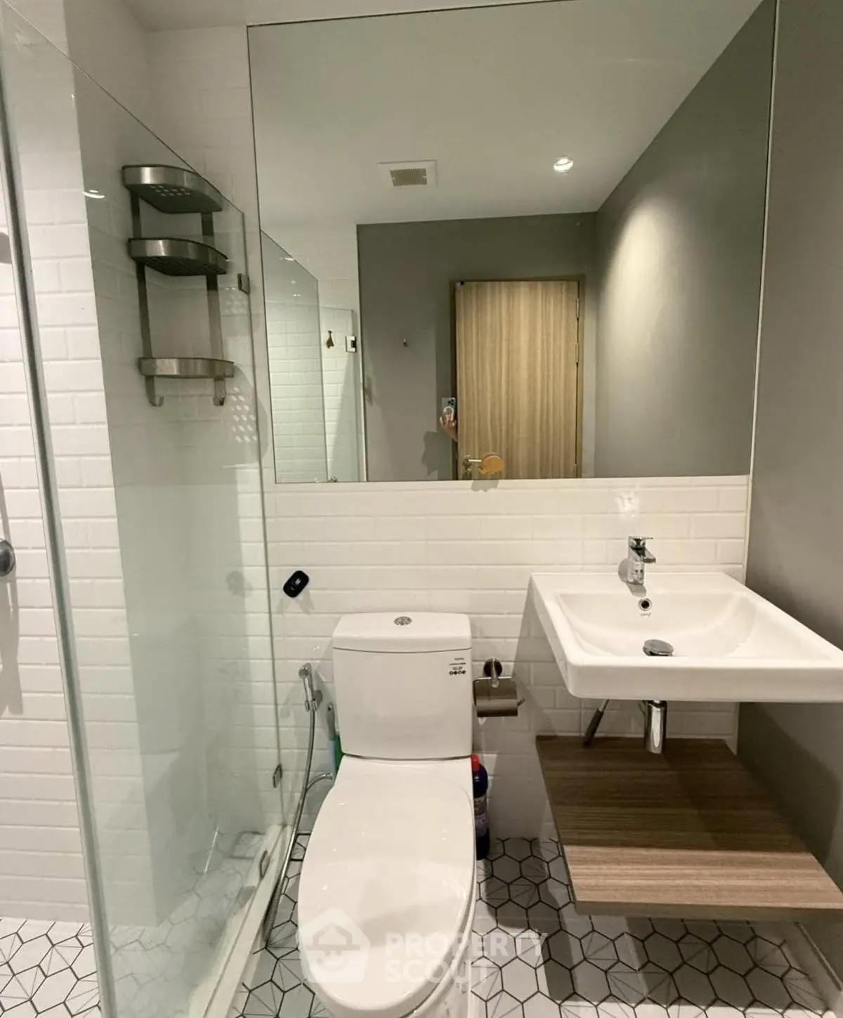 Modern bathroom with sleek fixtures and glass shower enclosure.