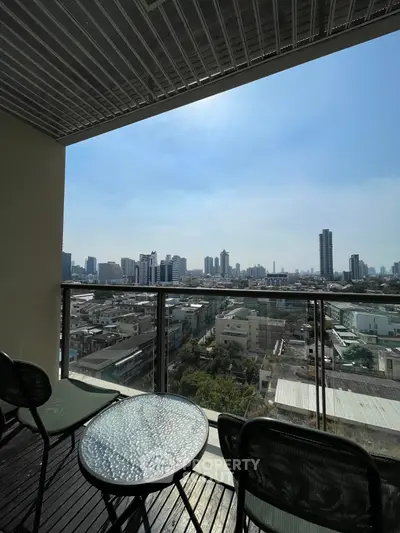 Stunning cityscape view from a modern balcony with stylish outdoor seating.
