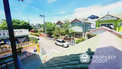 Charming suburban neighborhood view with colorful houses and clear blue sky.