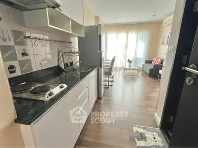 Modern open-layout kitchen and living room with sleek appliances and stylish decor.