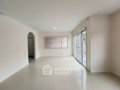 Spacious empty living room with large windows and neutral tones