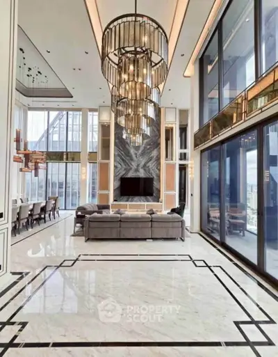 Luxurious modern living room with high ceilings, elegant chandeliers, and floor-to-ceiling windows offering stunning views.