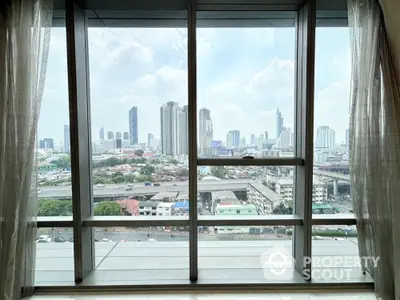 Stunning cityscape view from high-rise apartment window with skyline backdrop.