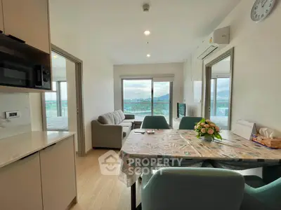 Modern open-layout living room with mountain view, featuring stylish furniture and natural light.
