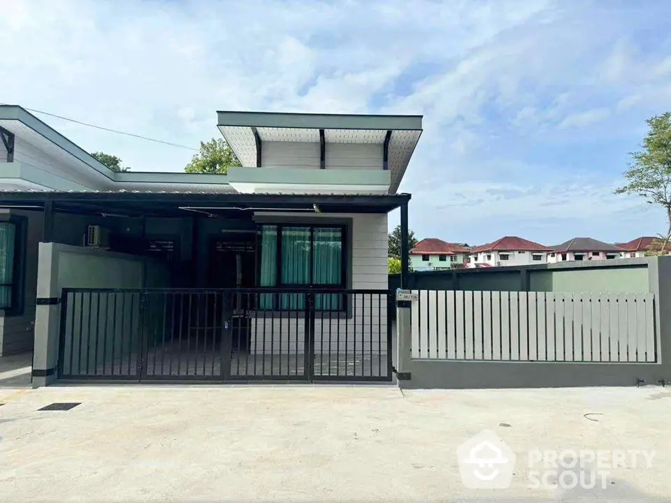 Modern single-story house with gated entrance and spacious driveway