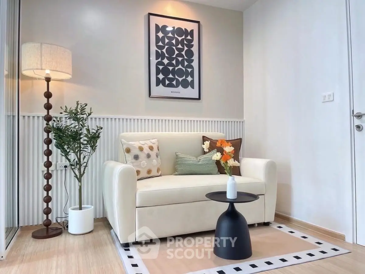 Cozy living room with modern decor, featuring a stylish sofa, elegant floor lamp, and chic wall art.