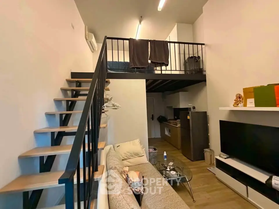 Modern loft apartment with mezzanine, stylish staircase, and cozy living area, perfect for urban living.
