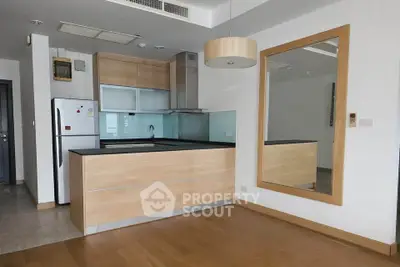 Modern kitchen with sleek wooden cabinetry and open layout in a stylish apartment.