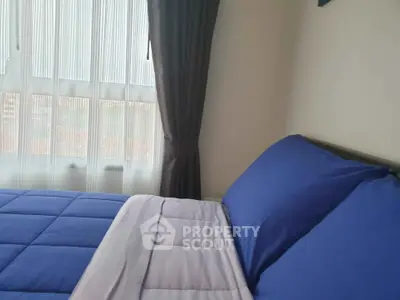 Cozy bedroom with blue bedding and large window view