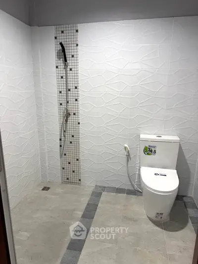 Modern bathroom with sleek white tiles and contemporary fixtures.
