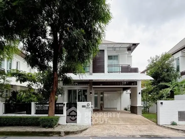 Elegant two-story house with spacious driveway and lush greenery in a serene neighborhood.