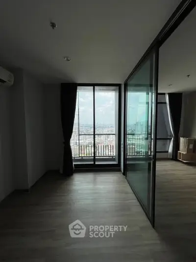 Spacious modern apartment with large windows and city view, featuring sleek flooring and elegant curtains.