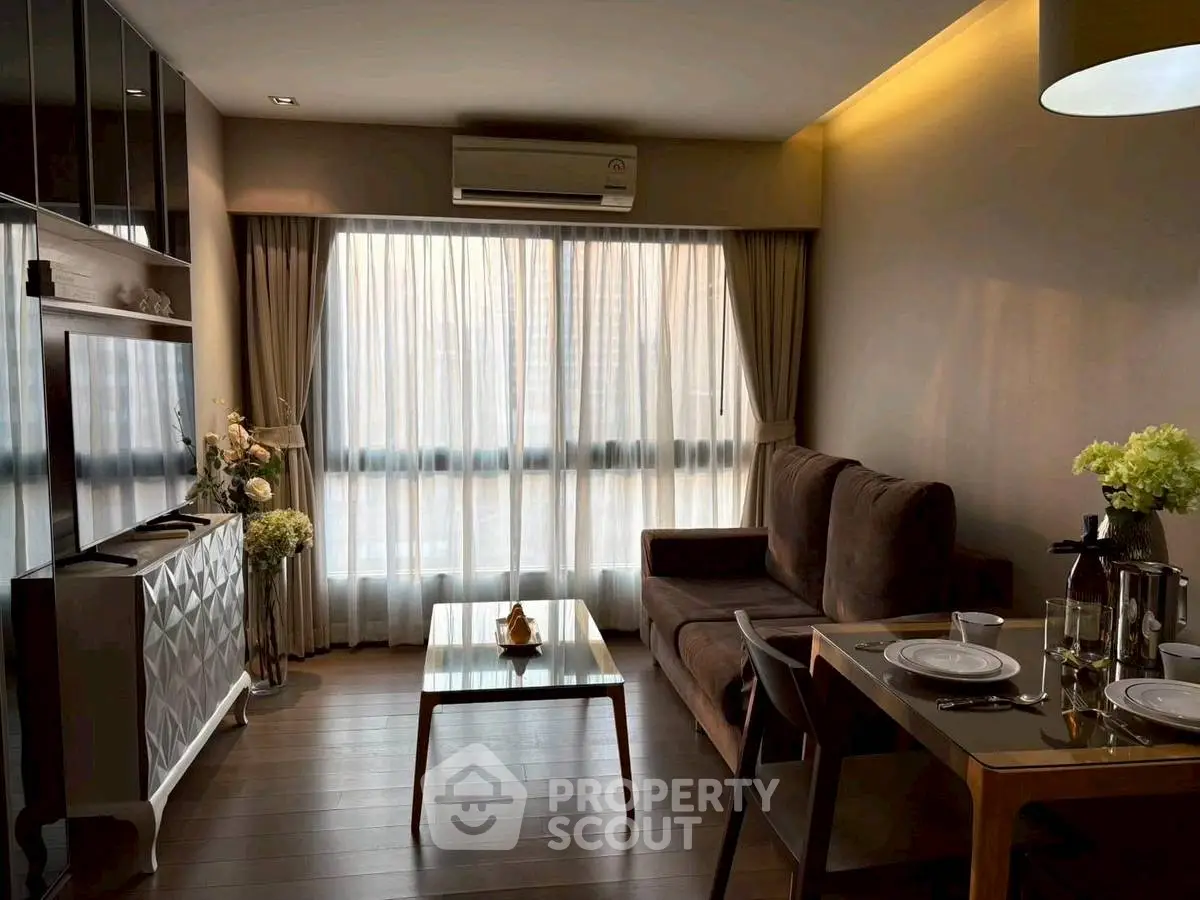 Modern living room with elegant decor and large window, featuring a cozy sofa and dining area.