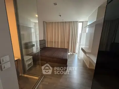 Modern bedroom with glass partition and elegant curtains in a stylish apartment.