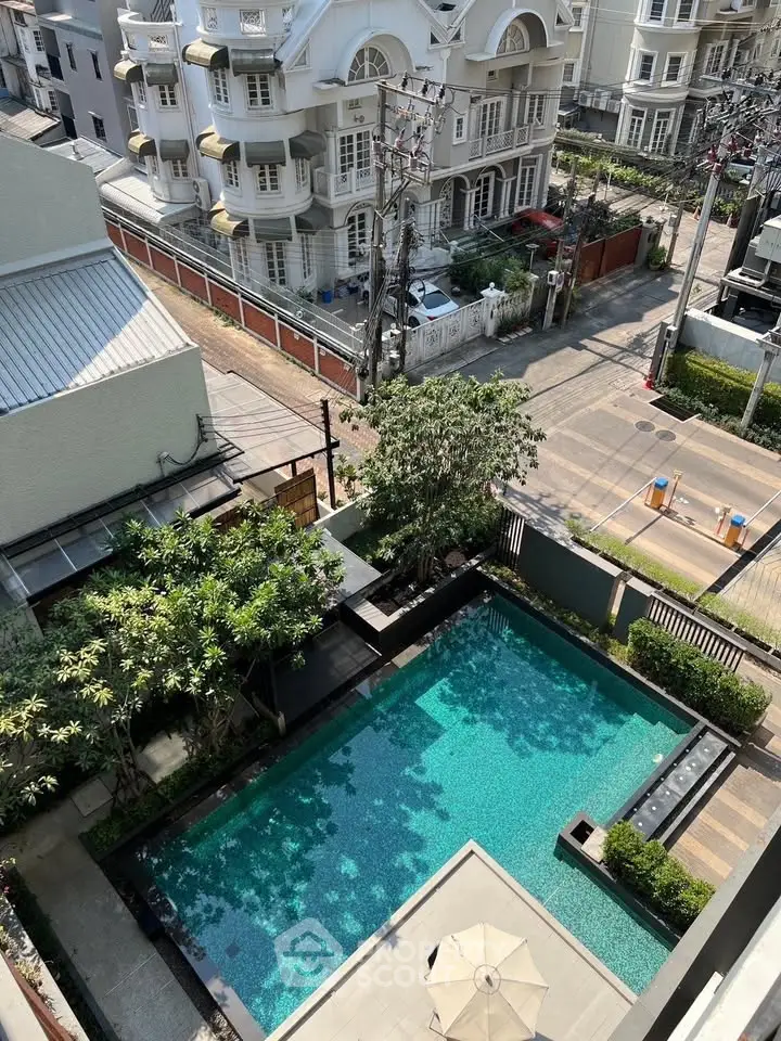 Stunning aerial view of luxurious residential pool and elegant neighborhood.