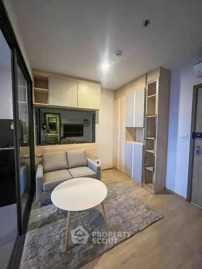 Modern living room with cozy sofa and stylish decor in a compact apartment.