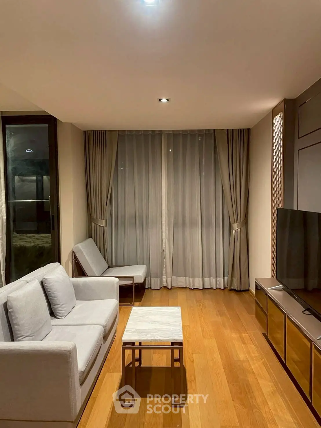 Elegant living room with modern furniture and wooden flooring, perfect for relaxation and entertainment.