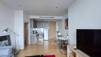 Modern open-plan living room with kitchen, featuring sleek furniture and contemporary design.