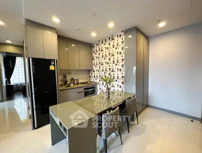 Modern kitchen with sleek cabinetry and dining area in stylish apartment