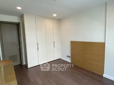 Spacious bedroom with wooden flooring and built-in wardrobe