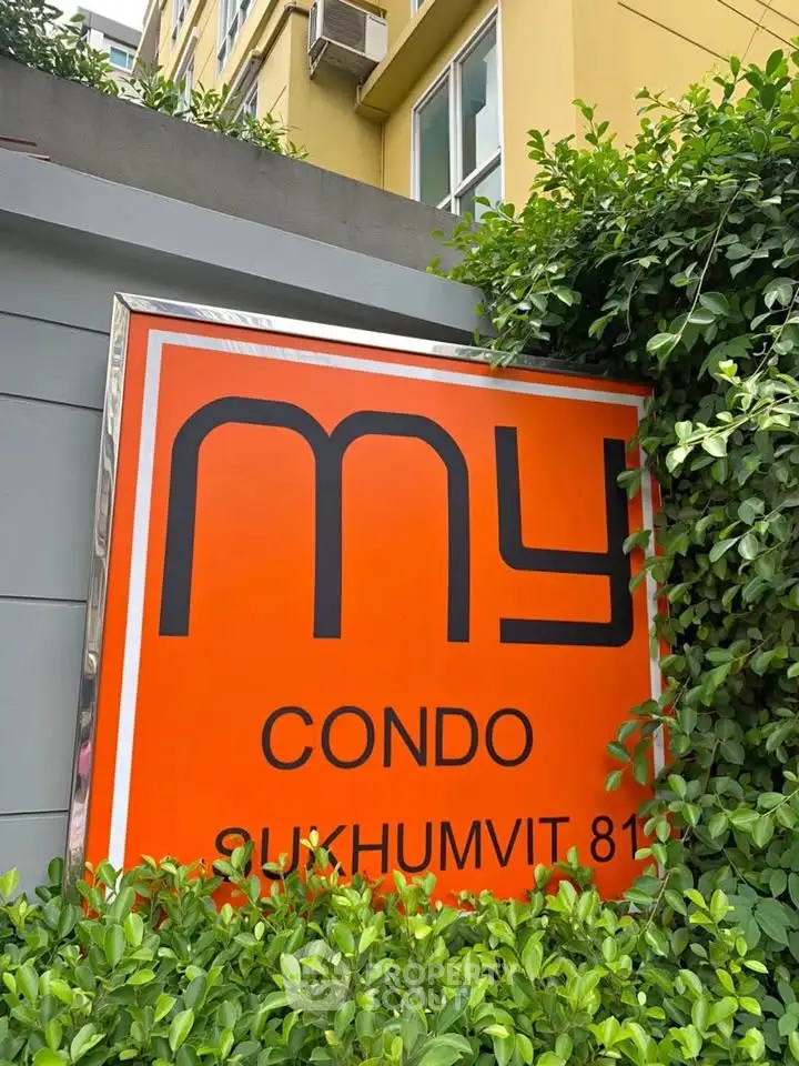 Modern condo entrance sign with vibrant orange design at Sukhumvit 81.