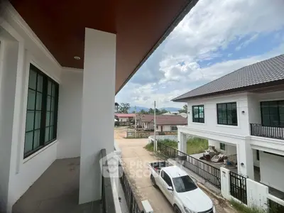 Modern residential view from balcony with clear sky and parked car