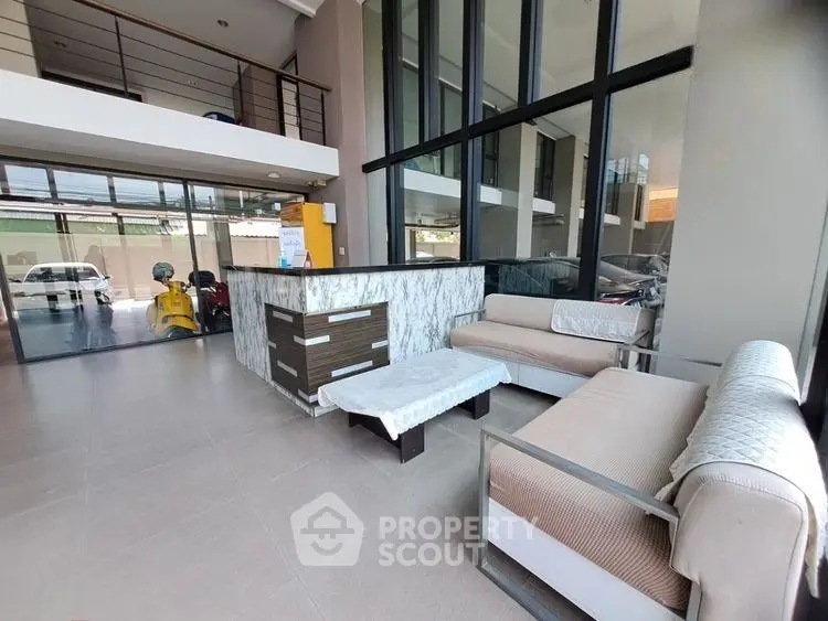 Modern lobby with stylish seating and large windows in a contemporary building.