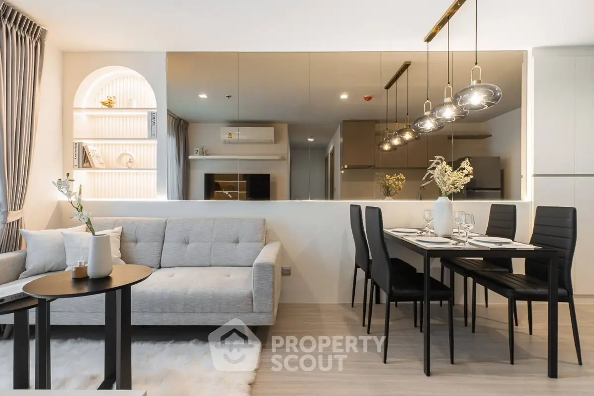 Modern open-plan living and dining area with stylish lighting and cozy decor.