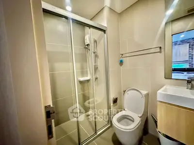 Modern bathroom with glass shower and sleek fixtures in a contemporary apartment.