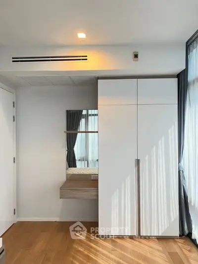 Modern bedroom with sleek wardrobe and natural light