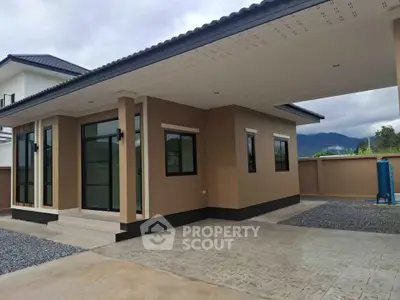 Modern single-story home with sleek design and mountain views, featuring large windows and a spacious driveway.