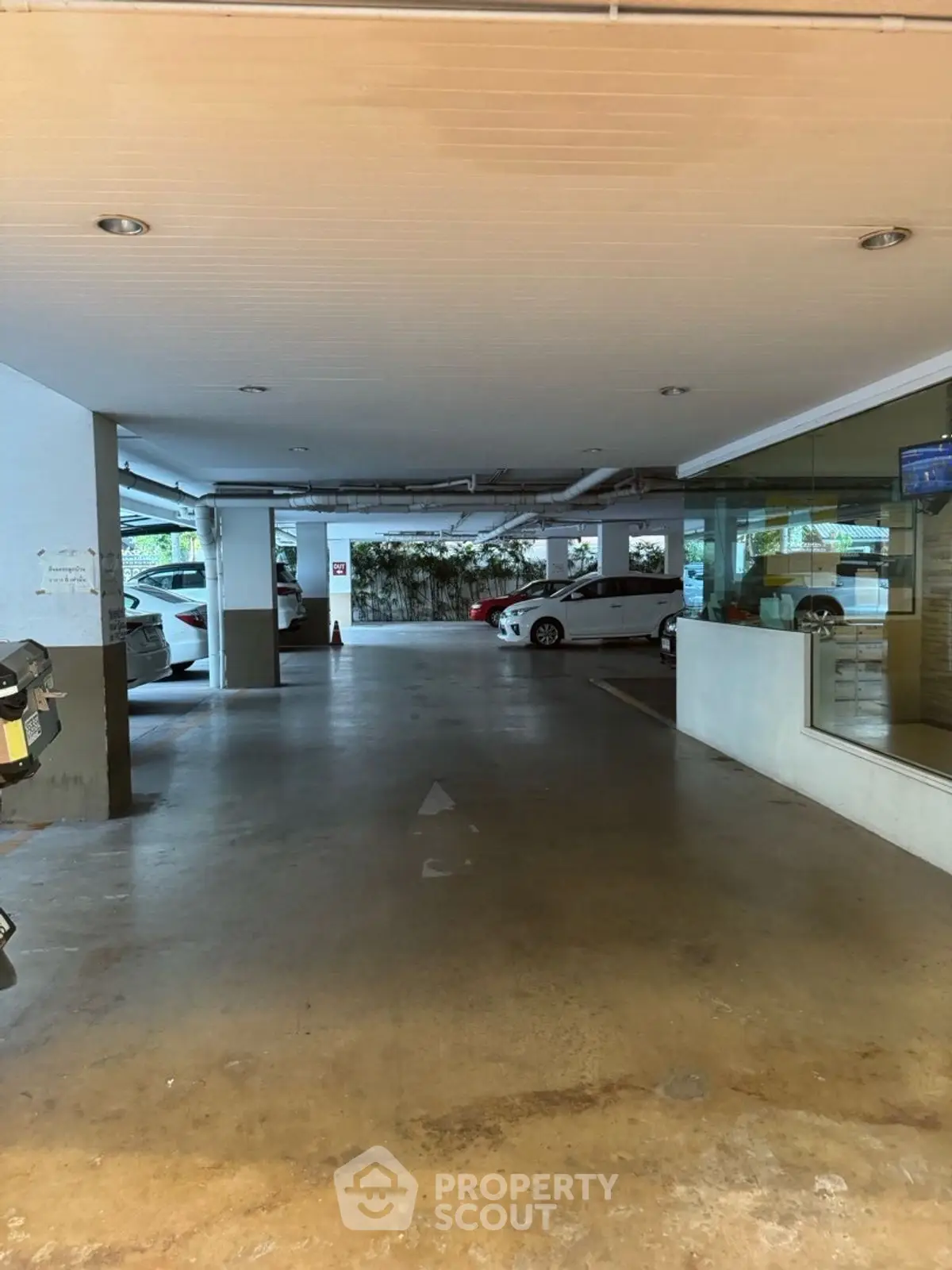 Spacious covered parking area with multiple cars and clear pathways.