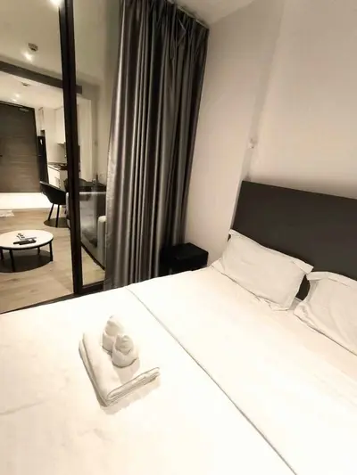 Modern bedroom with elegant decor and cozy ambiance, featuring a neatly made bed and stylish furnishings.