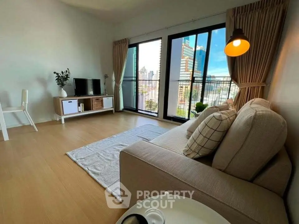 Modern living room with city view, featuring cozy sofa and stylish decor in high-rise apartment.
