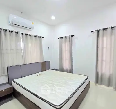 Spacious bedroom with modern air conditioning and ample natural light.