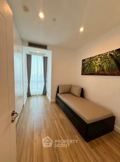 Cozy minimalist bedroom with wooden flooring and large window view