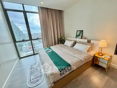 Modern bedroom with large window and city view, featuring stylish decor and cozy ambiance.