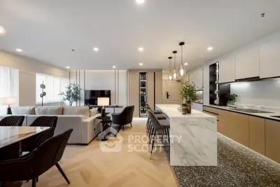 Luxurious open-plan living room and kitchen with modern furnishings and elegant lighting.