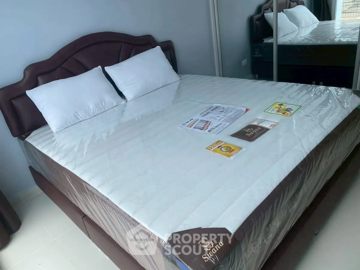 Spacious bedroom with elegant bed and mirrored wardrobe in modern apartment.